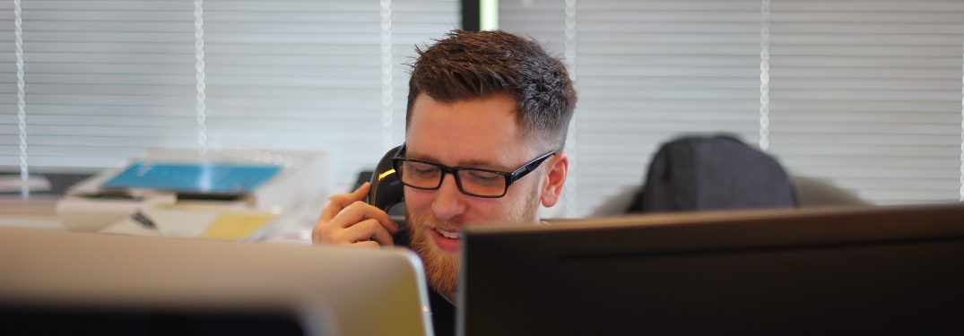 man talking on phone sitting at desk