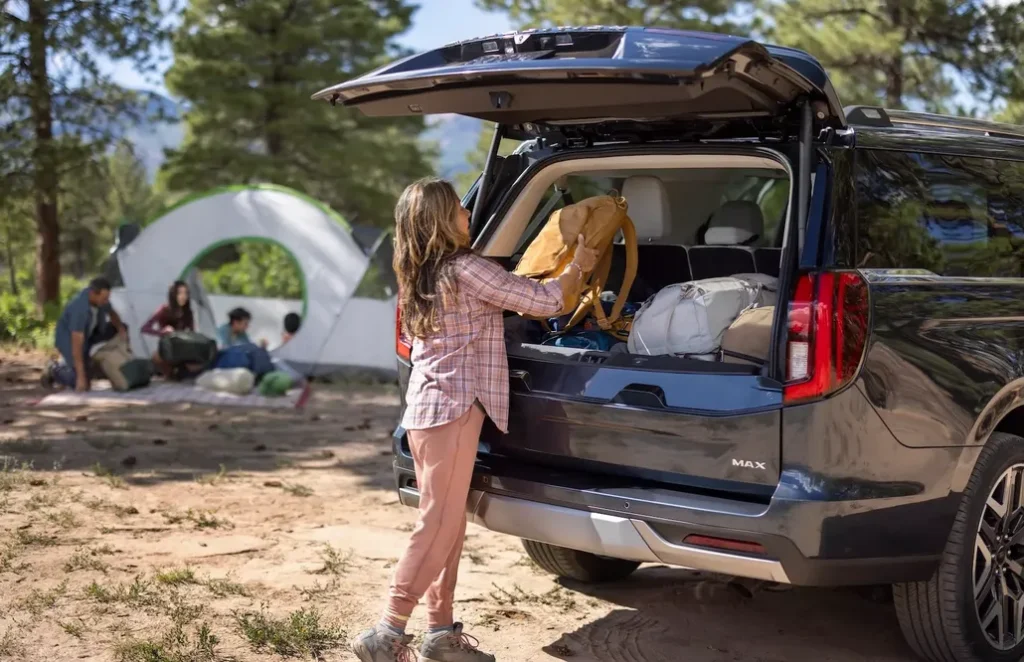 Ford Customer Putting a Camping Bag in Their Ford Expedition Using the Split Tailgate
